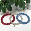 Crystals and Creations triple stretch bracelet set in red, white, and blue gemstone beads with a silver star charm.